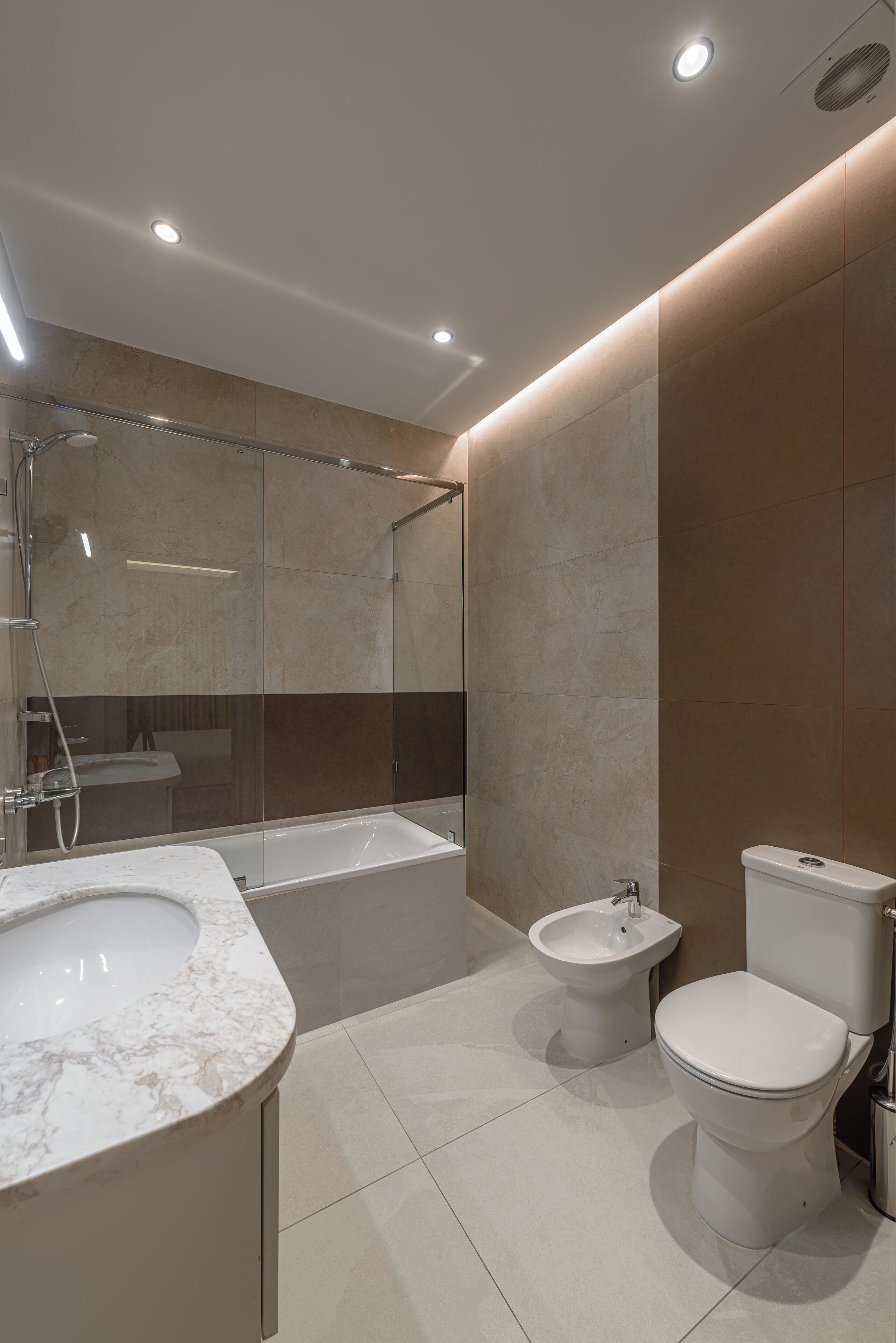 A modern bathroom with a bathtub, a bidet, and a toilet.