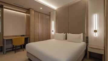 Una camera d'albergo moderna con un letto grande, una scrivania e una sedia.