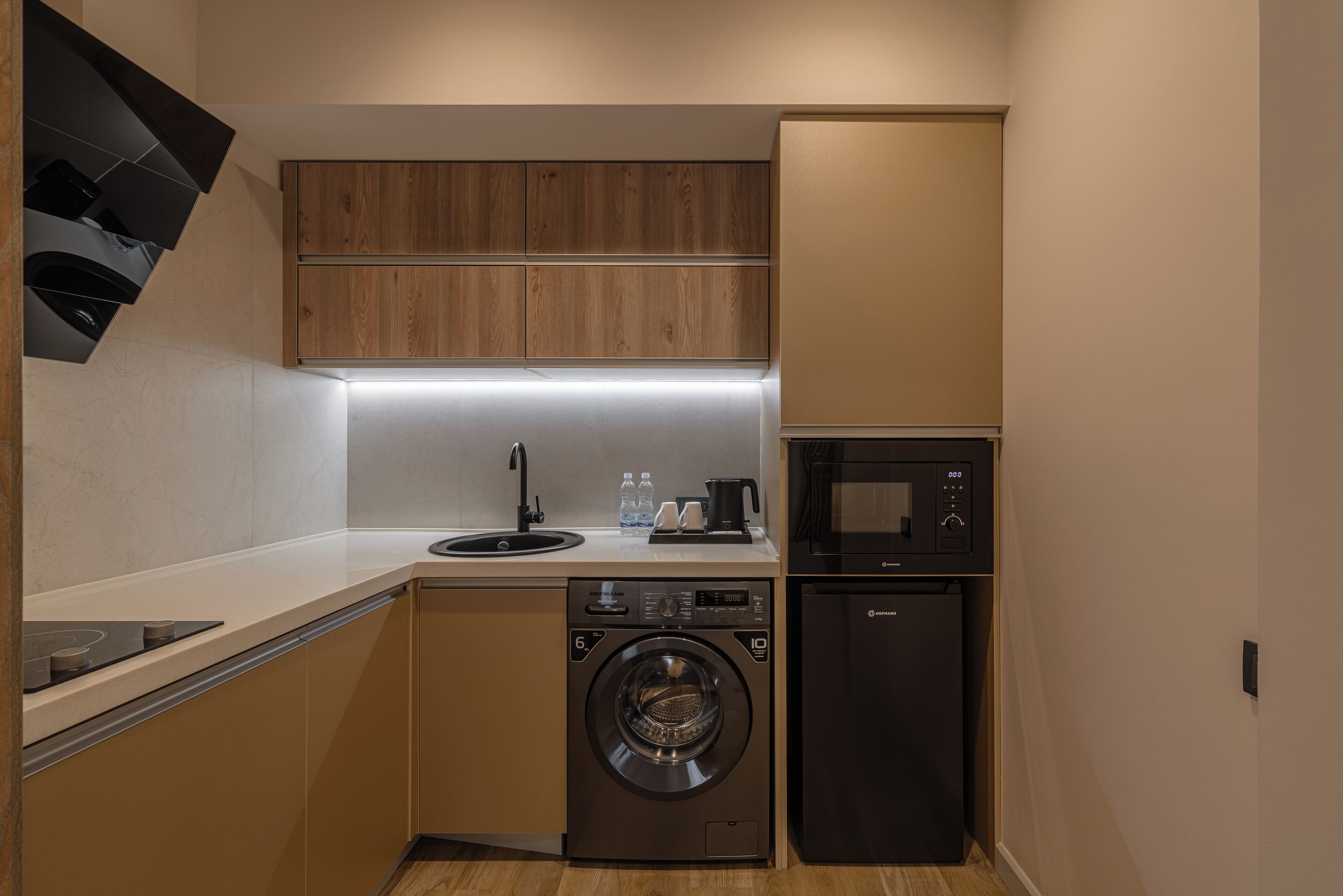 A compact kitchen with a washing machine, a microwave, and a sink.
