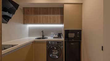 Cocina compacta con lavadora, microondas y lavaplatos.