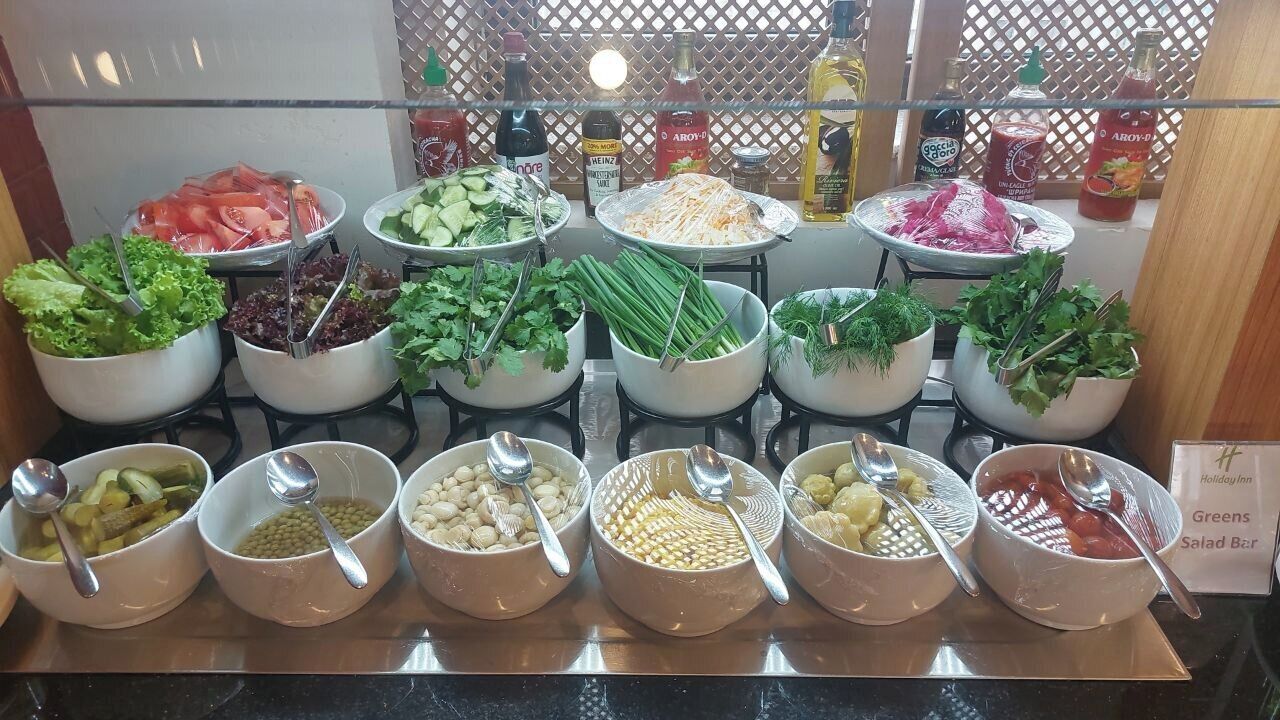 A buffet with various salads and condiments.