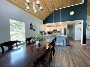 A modern kitchen with white cabinets, stainless steel appliances, and a wooden ceiling. - The Great Escape Chalet @ Spring Brook Resort (Wisconsin Dells)