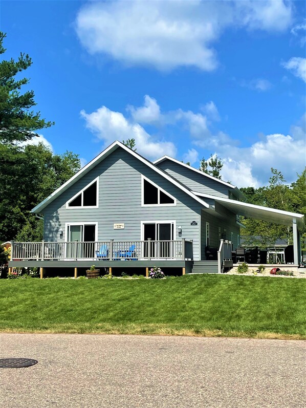 A two-story house with a covered porch and a small deck. - The Great Escape Chalet @ Spring Brook Resort (Wisconsin Dells)
