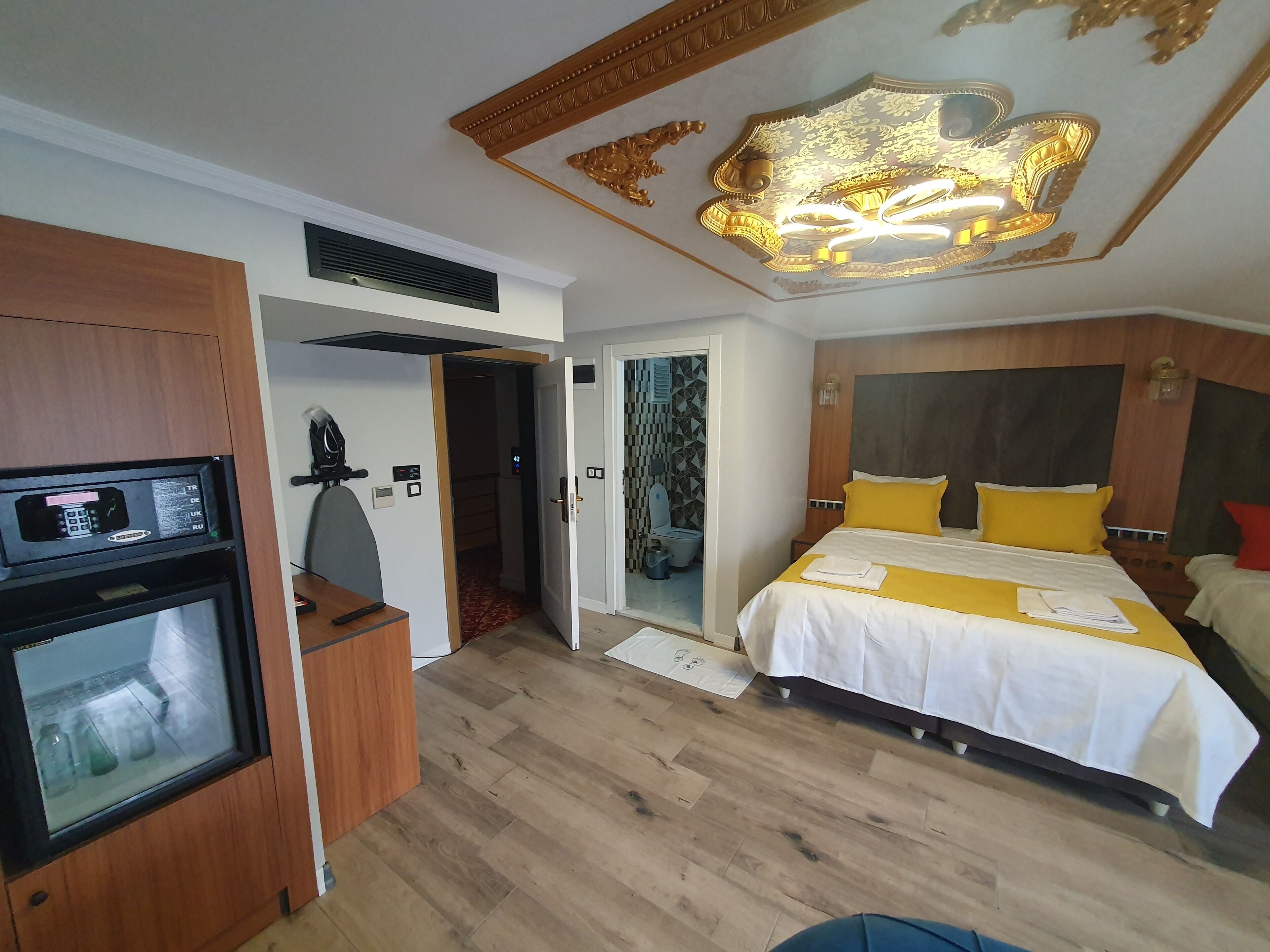 A hotel room with a bed, bedside table, and a built-in TV.