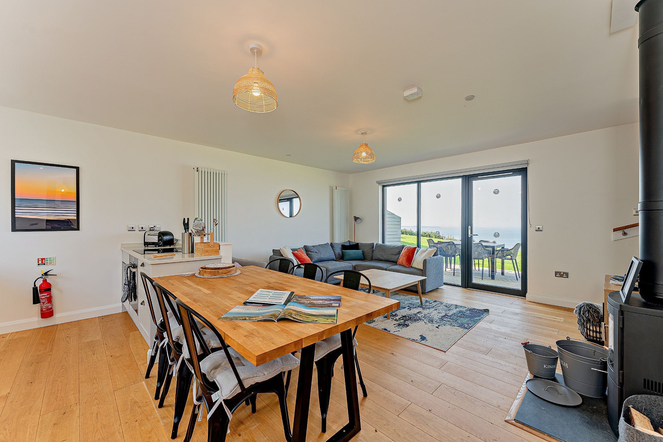 Un salón espacioso con una mesa de comedor de madera, un sofá y un amplio ventanal con vistas al exterior.