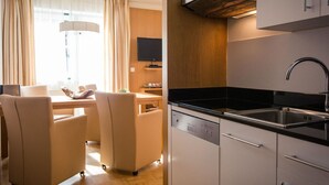 Une cuisine moderne équipée d’un lave-vaisselle, d’un évier et d’un four encastré. Un coin repas avec une table et des chaises est également disponible.