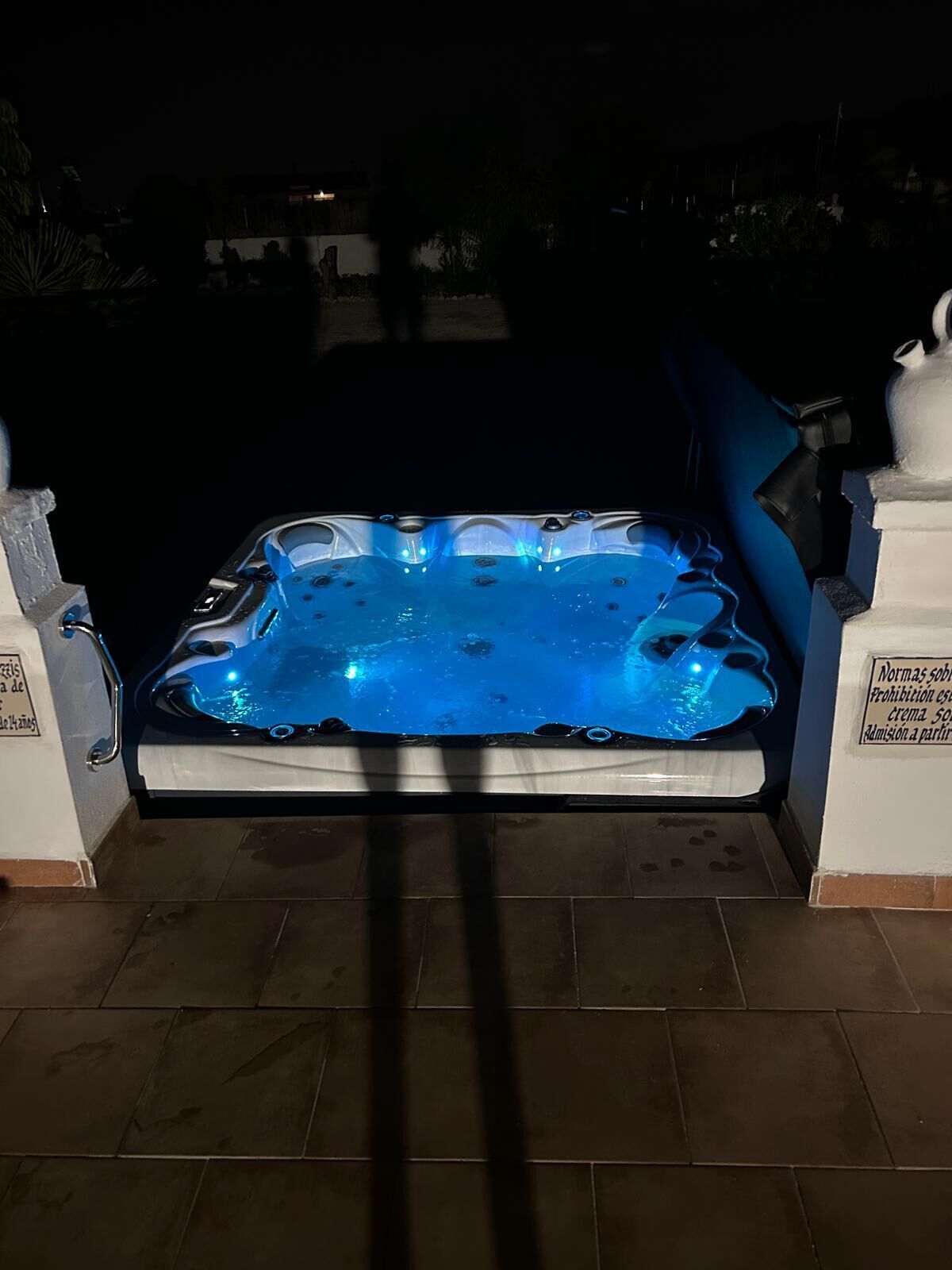 Een jacuzzi met betegelde vloer en een witte rand.