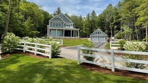 A two-story house with a large front porch and a garage. - Timeless Memories on Newfound Lake (Hebron)