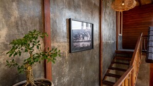Una escalera con barandillas de madera, una planta en maceta y una fotografía enmarcada en la pared.