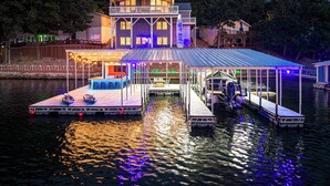 Une maison située au bord de l’eau, dotée d’un quai couvert et d’un espace bar.