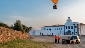 A yellow hot air balloon with the text "Uma história que nunca acaba" flying above a building. - Convento da Orada (Reguengos de Monsaraz)