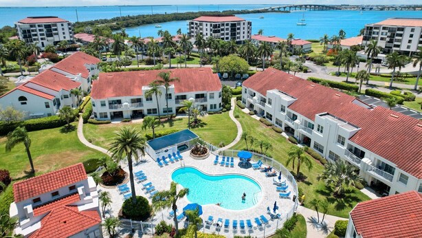 Een resort met meerdere gebouwen, een centraal zwembad en uitzicht op de oceaan.