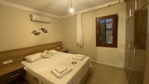 Habitación de hotel con cama, mesita de noche, armario y ventana.