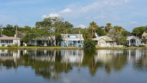 A waterfront property with multiple houses, a calm lake, and surrounding greenery. - Splendor on the Lake, 1928 Cottage-Walk Everywhere (Saint Augustine)