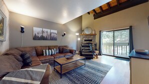 Un salón amplio con un sofá de cuero, una mesa de centro y una chimenea.