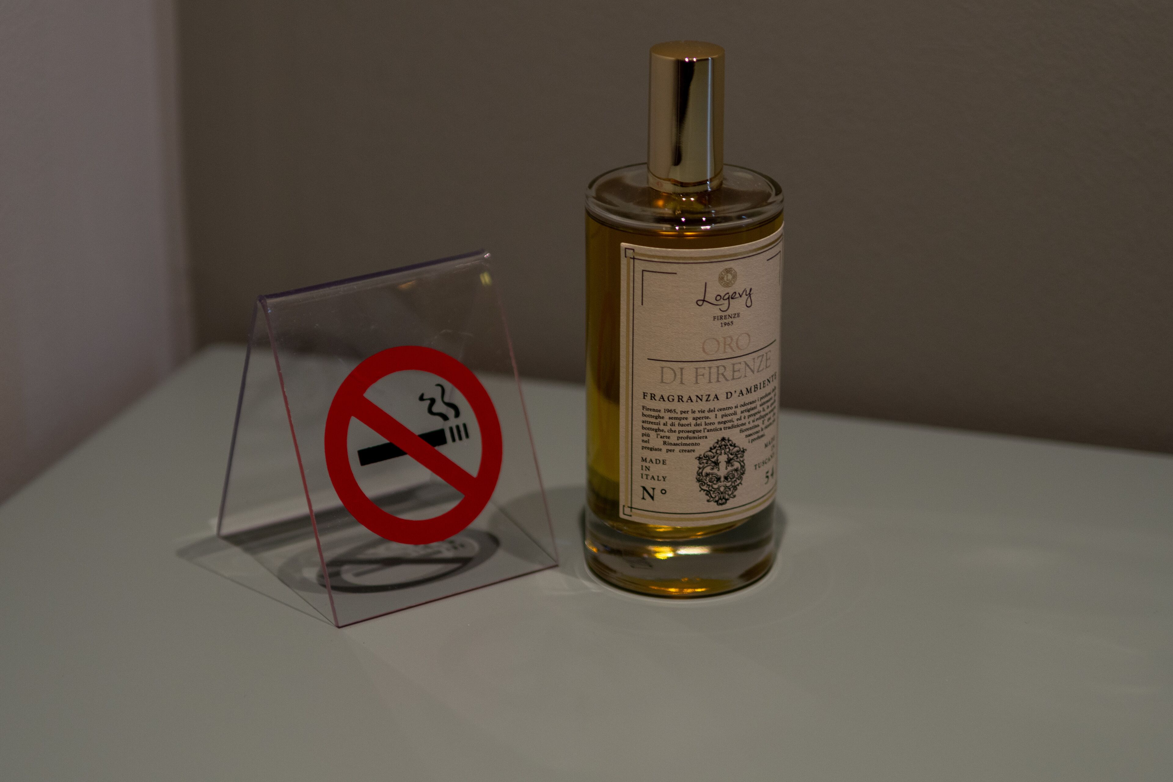 Une bouteille de liqueur dont l’étiquette porte l’inscription : « Leggey Firenze ORO DI FIRENZE FRAGRANZA D’AMBIENTI MADE IN ITALY. »