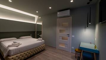 A bedroom with a bed, a desk, and a wardrobe.