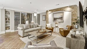 Ein modernes Wohnzimmer mit Sofa, Sesseln, Couchtisch und Kamin.