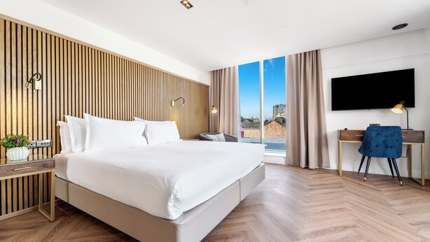 A modern hotel room with a large bed, a desk, and a TV. - Ropewalks Hotel (Liverpool)