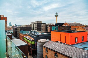 Paesaggio urbano con diversi stili architettonici, tra cui una torre importante e un mix di architettura moderna e tradizionale.