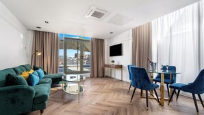 A modern living room with a green sofa, a glass table, and blue chairs. - Ropewalks Hotel (Liverpool)