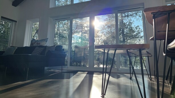 Ett rymligt vardagsrum med ett stort fönster, en soffa och ett bord.