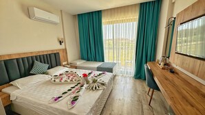 Quarto de hotel com duas camas, uma escrivaninha de madeira, uma televisão e uma varanda com cortinas.