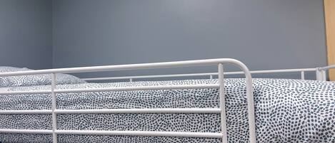 A bunk bed with a patterned mattress in a room with grey walls.