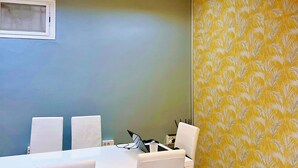 A conference room with a white table, white chairs, and a ceiling light fixture. - Hostel Acacias (Madrid)