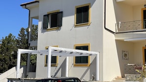 Ein zweistöckiges Gebäude mit Balkon und überdachter Terrasse.