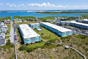 Un hotel sulla costa con diversi edifici, aree di parcheggio e vista sull'oceano.