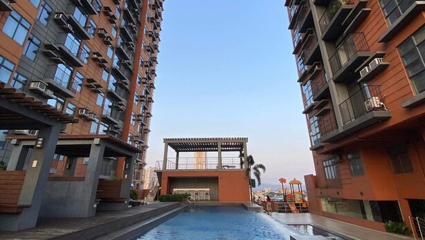 A modern residential building with a central courtyard featuring a swimming pool.