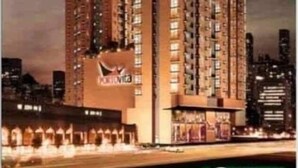 A high-rise hotel building with multiple floors, a prominent logo on the facade, and a well-lit entrance area.