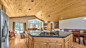 A spacious kitchen with a large island, wooden ceiling, and a view of the outdoors. - Alpine Family Adventure - Pets, BBQ, Games (South Lake Tahoe)