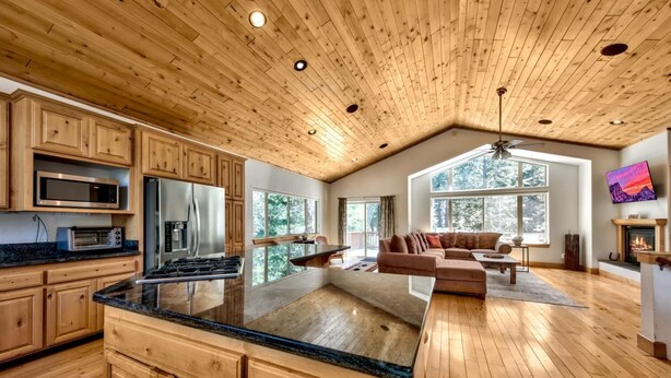 A spacious kitchen with wooden cabinets, a large island, and modern appliances. - Alpine Family Adventure - Pets, BBQ, Games (South Lake Tahoe)