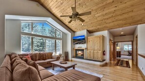 A spacious living room with a large sectional sofa, a fireplace, and a wooden ceiling. - Alpine Family Adventure - Pets, BBQ, Games (South Lake Tahoe)