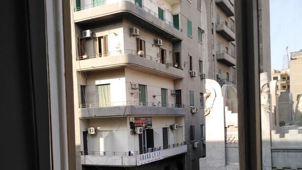 A multi-story building with balconies, air conditioning units, and a sign that reads "GRAND LLOYD". - Panorama Palace hotel  (Cairo)