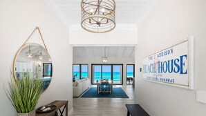 A modern interior with a view of the ocean, a dining area, and a sign indicating 'The Addison Beach House' in Great Exuma, Bahamas. - "New" 5 bedroom Exuma Beach Front Estate w/ Pool & No Neighbors on either side! (Harts)