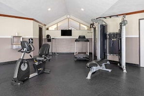 Ein Fitnessstudio mit Ergometer, Laufbändern und Gewichten.