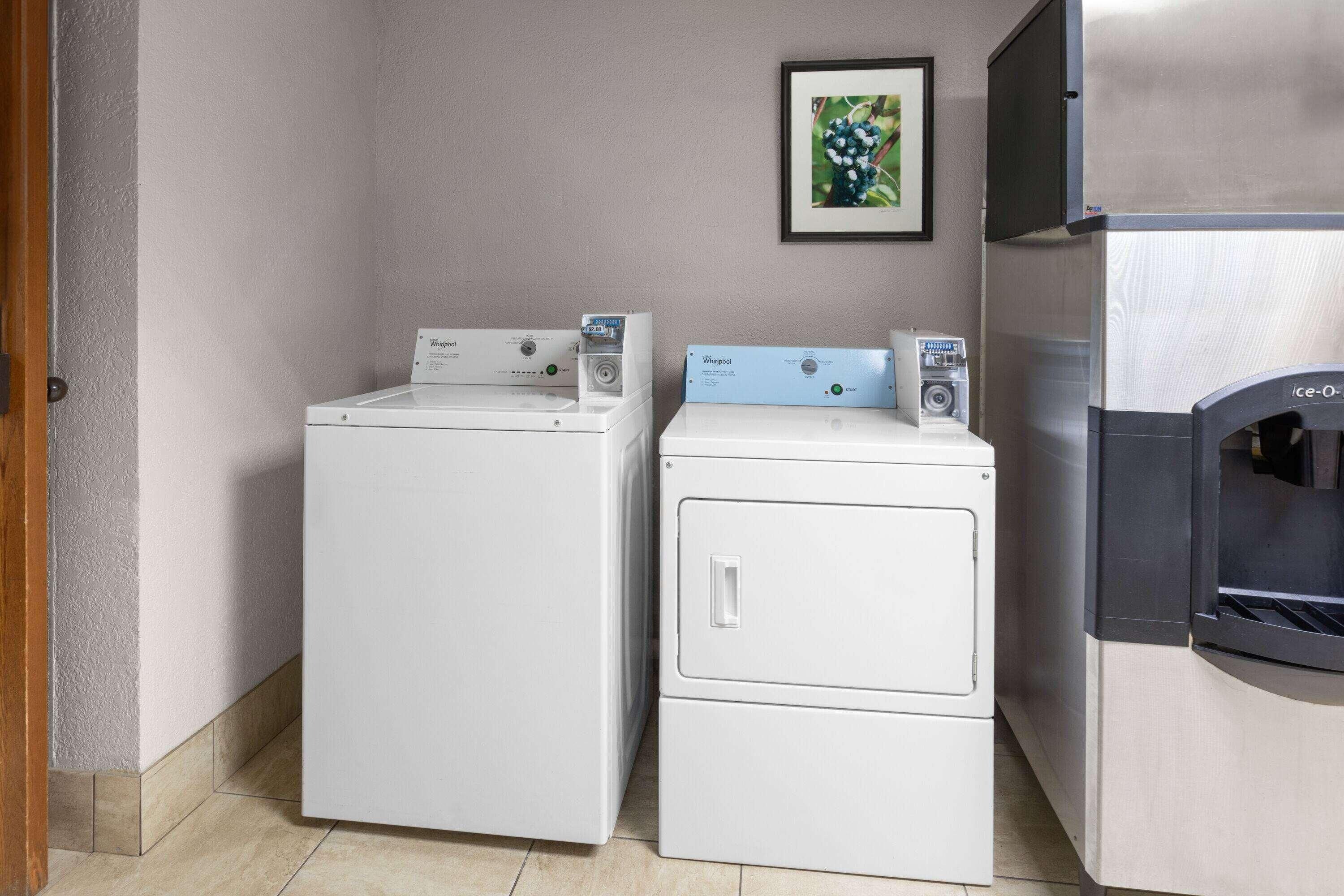 A laundry area with two washing machines and a refrigerator.