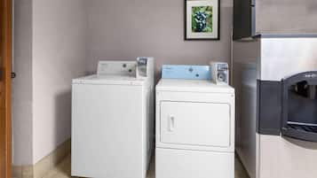 A laundry area with two washing machines and a refrigerator.