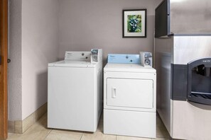 A laundry area with two washing machines and a refrigerator.