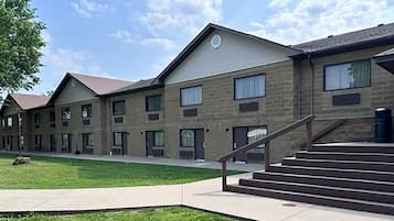 A multi-story building with a brick facade, multiple windows, and a central staircase.