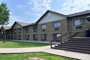 A multi-story building with a brick facade, multiple windows, and a central staircase.