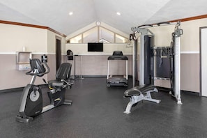 A gym with stationary bikes, a treadmill, and weightlifting equipment.