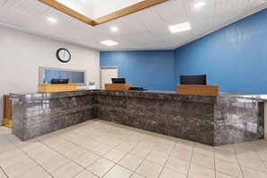 A reception area with a marble counter, a clock, and a window. - Baymont Inn And Suites By Wyndham Farmington Mo (Farmington)