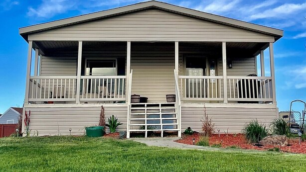 A single-story house with a front porch and a garage. - Wyoming Prairie Place (Gillette)