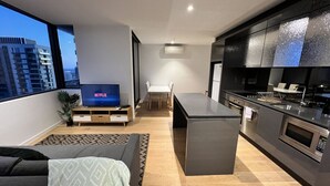 A modern apartment with a living room, dining area, and kitchen. - 2 BR in High-Rise Building at Manhattan (Melbourne)