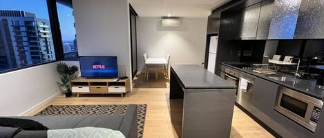 A modern apartment with a living room, dining area, and kitchen.