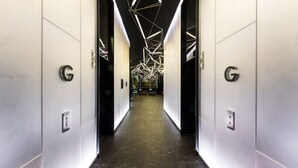 A modern elevator lobby with geometric ceiling lighting and a dark floor. - 2 BR in High-Rise Building at Manhattan (Melbourne)